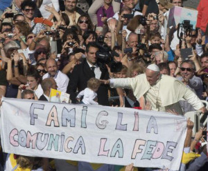 Pope Francis is driven past a banner reading "Family communicates faith" as he leaves St. Peter's Square at the Vatican, Sunday, Oct.27, 2013. Pope Francis led a Mass on the occasion of the meeting with families. (AP Photo/Alessandra Tarantino)